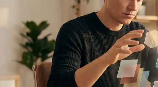 Designer UX/UI professionnel concentré sur son travail d'interface avec des éléments visuels abstraits