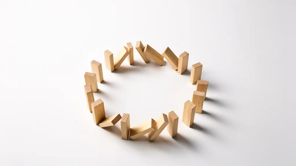 Composition minimaliste de dominos en bois naturel disposés en cercle, certains debout, d'autres en chute suspendue